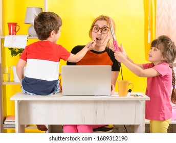 Working from home.Woman work on laptop with children playing around. Children make noise and disturb mom at work. Busy parent 