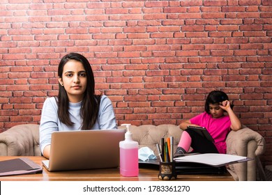 Working Indian Mom Works From Home Office With Kid in Pandemic. Woman And Cute Child Using Laptop. Freelancer Workplace In Cozy Home. Happy Mother And Daughter.