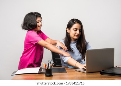 Working Indian Mom Works From Home Office With Kid in Pandemic. Woman And Cute Child Using Laptop. Freelancer Workplace In Cozy Home. Happy Mother And Daughter.