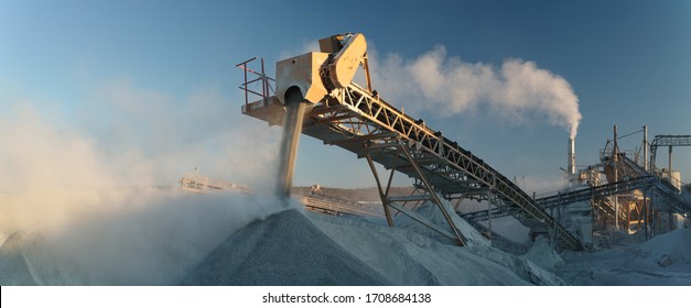 Working Industrial Equipment Of A Crushing And Processing Plant In A Plume Of White Stone Dust, Panorama.