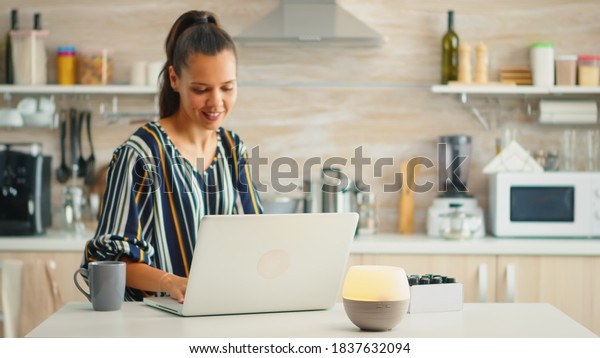 Working in the\
kitchen with essential oils diffuser steaming. Aroma health\
essence, welness aromatherapy home spa fragrance tranquil theraphy,\
therapeutic steam, mental health\
treatment