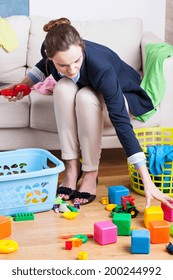 Working Lady Cleaning Up Colorful Kids Toys 