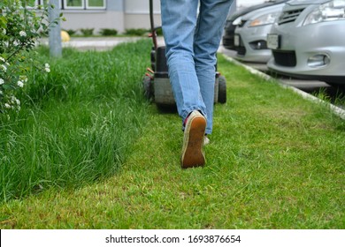 Working lawn mower on green lawn with trimmed grass.
