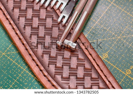 Working with leather creating stamping pattern on the sheath