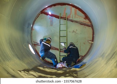 Working male two inspection weld PT test weldment for finding defect  underground of tank equipment tunnel By using the flashlight in side confined ( penetrant with cleaner by fabric )