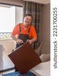 A working man assembles a coffee table. Hotel worker screwing the leg table.