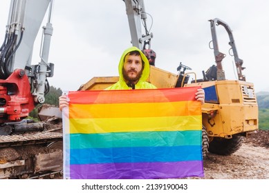 Working Man On A Construction Site Holding A Rainbow Lgbt Pride Flag Demanding Equal Treatment At His Job. Concept Of Sexual Discrimination In Employment.