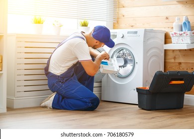 Working Man Plumber Repairs A Washing Machine In   Laundry
