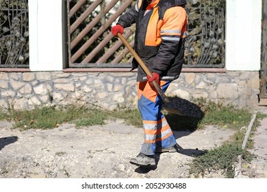 A Working Man In Uniform Holding A Shovel In His Hands At A Highway Construction Site