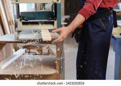 Working man using thickness planer at carpentry shop, closeup