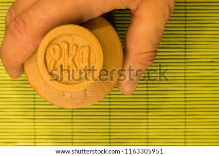 Working mans hand holds 2kg weight balance measurement on green background