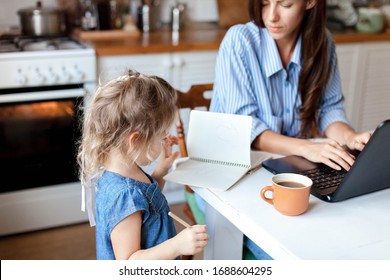 Working mom works from home office with kid. Stressed woman using laptop. Child drawing, spoiling mother notebook. Freelancer workplace in kitchen. Remote female business, career. Lifestyle moment