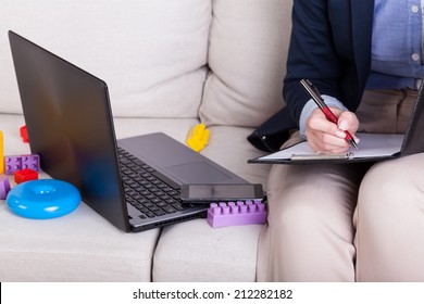 Working Mother Among Child's Toys At Home