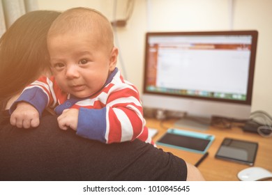 Working Mother With A Baby And Her Computer
