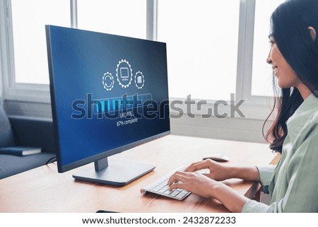 Working in office desktop Installing update system software for device operating systems to be up to date with the new version. Graphics icon showing updating function screen loading on computer.
