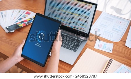 Working in office desktop Installing update system software for device operating systems to be up to date with the new version. Graphics icon showing updating function screen loading on tablet.