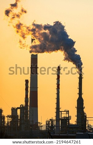 Working oil refinery. Smoke from the factory chimney. Ecological pollution. Air emissions polluting the city. Industrial waste is hazardous to health. Large factory in smog, Production in operation.