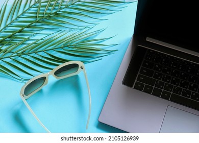 Working On The Beach While On Vacation Concept Photo. Online Job, Education Image. Open Laptop, Sunglasses And Palm Leaves Top View 