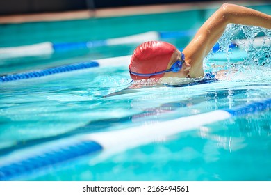Working on her stroke. Shot of a professional female swimmer freestyle swimming in her lane. - Shutterstock ID 2168494561