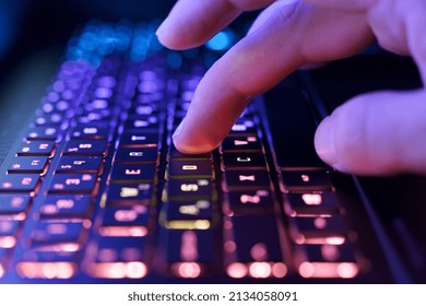 Working on a neon computer keyboard with colored backlighting. Computer video games, hacking, technology, internet concept. Selected focus.