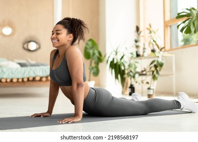 Working Out At Home. Fit Black Lady Stretching, Doing Cobra Exercise Or Standing In Upward-facing Dog Posture On Fitness Mat, Wearing Sportswear, Copy Space