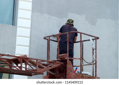  working painter paints the facade of the building                              