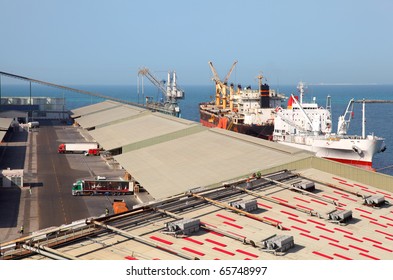 Working people ship cargo boats at the Abu Dhabi industrial port