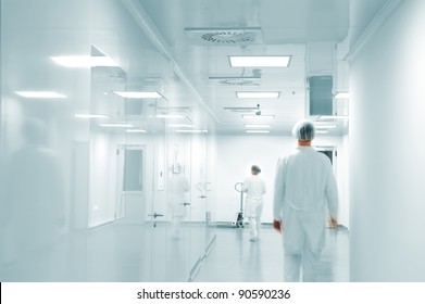 Working People With White Uniforms In Modern  Factory Environment