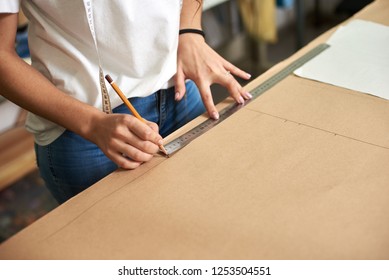 Working place in design studio. Professional female designer hands close-up making paper patterns using measuring tape, ruler. Exclusive clothes making, creative occupation concept. - Powered by Shutterstock