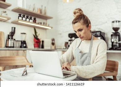 Working Place. Focused Smart Cafe Owner Sitting At The Table Working At Her Laptop.