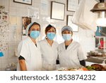 Working portrait of a fishmonger with workers. Three women attending the public. Sale of fish to customers.