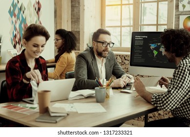 Working process. Colleagues from marketing department discussing details while working on a project - Shutterstock ID 1317233321