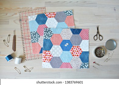 Working Process: Hexagon Quilt, Threads, Retro Scissors, Pins, Metal Jar, Quilting Ruler And Seam Ripper On The Wooden Table