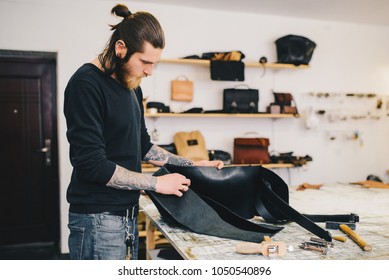 Working process of the leather bag in the leather workshop. Crafting tool on work table background. - Powered by Shutterstock