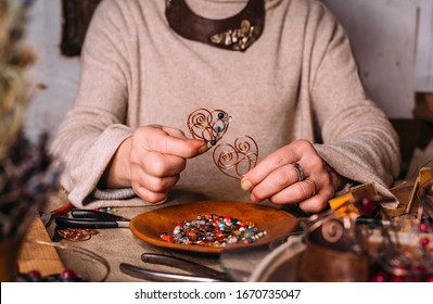 Working Process Making Jewelry For Wire Wrapped Bijouterie. Real Process. Craft Handmade Copper Wire Working Tools On The Table With Accessoires. Handicraft People Art Concept