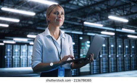 Working Process. Young Creative Caucasian Female Worker Looking Away while Using Laptop Computer in the Dark Evening Office. Businesswoman and e-Business Entrepreneur Concept - Powered by Shutterstock