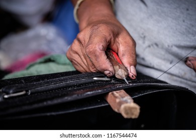 Working Repair Of The Leather Bag. Man Holding Crafting Tool And Working.Man Sewing To Repair A Bag.