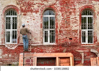 Working restorer restores the old wall of the building. Texture of old brick wall - Shutterstock ID 1038118882