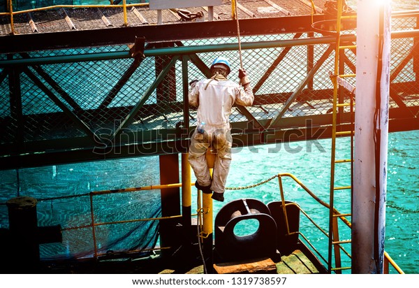 working at risk of the engineering or worker or\
labor on the sea platform, climbing to the top roof without safety\
equipments securing on the job\
site