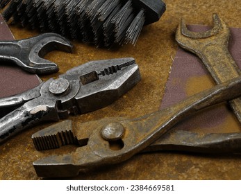 Working and rusty instruments open end wrench, pliers, rasp, hammer, awl  lie on the rusty sheets metal  in the workshop