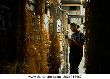 Working in Server Room with Network Cables and Equipment
