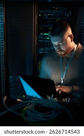 Working in Server Room Surrounded by Network Equipment