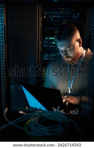 Working in Server Room Surrounded by Network Equipment