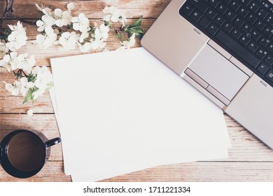 Working space or working place with laptop, cup of coffee and spring cherry blossom flowers on wooden background. Spring or business concept. Top view. Copy space. - Powered by Shutterstock