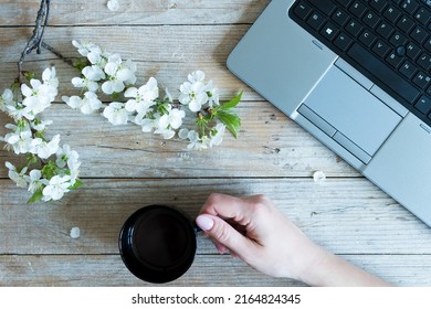 Working space or working place with laptop, cup of coffee and spring cherry blossom flowers on wooden background. Spring or business concept. Top view. - Powered by Shutterstock