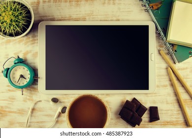 Working space. Tablet, notepad on wooden desk.
