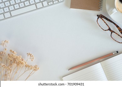 Working space with white background, glasses, book, pencil, dry flower and laptop, Mock up, Top view,  Closed up.