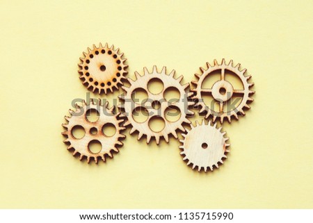 working system of cogwheels, teamwork, flat lay, pastel yellow background