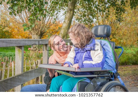 Similar – Woman carrying her mother in a wheelchair