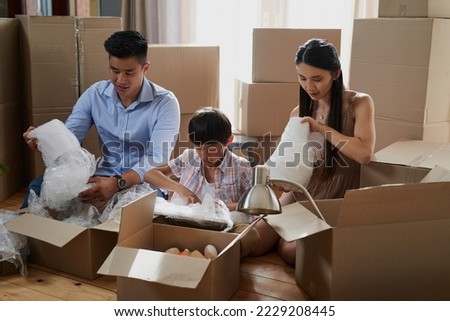 Working together as a family on moving day. Shot of a family packing boxes while moving house.